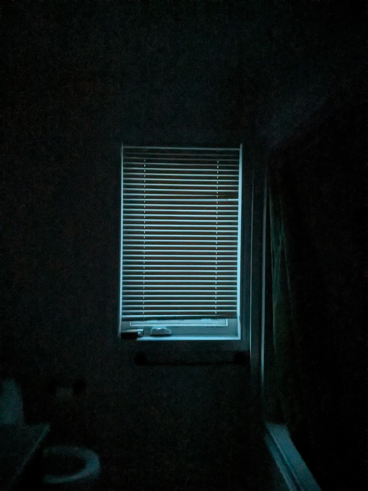 Dark room with only window blinds visible