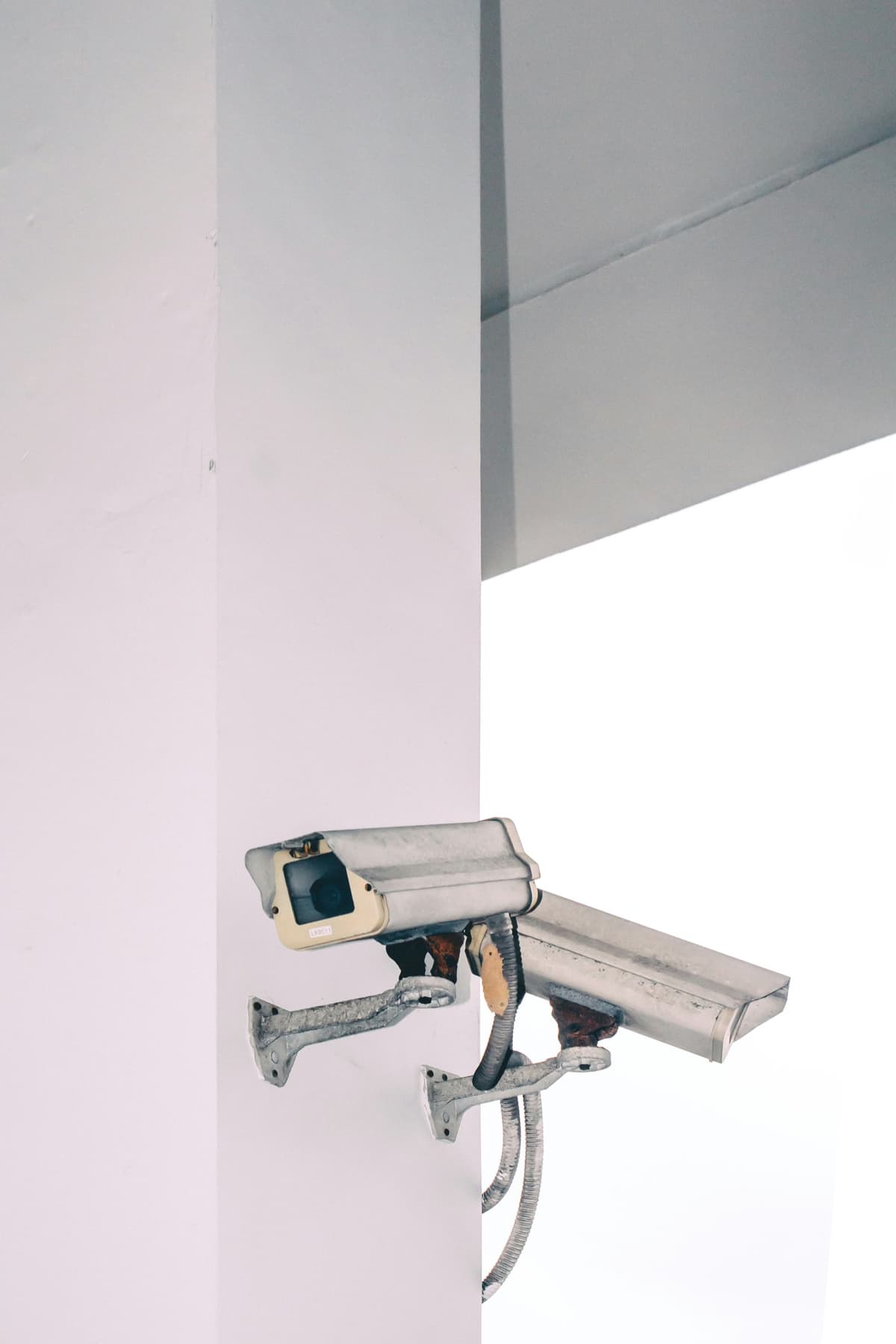 Weathered security cameras mounted on a wall